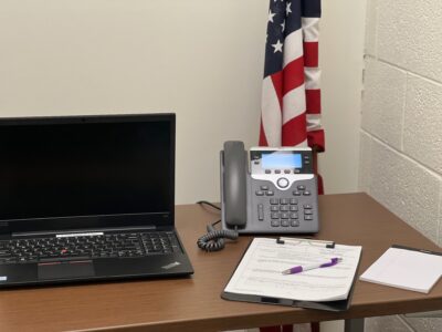 Desk with American flag, phone, computer, court filing paperwork.